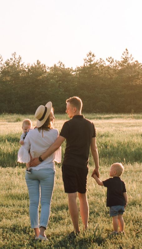 A young family going for a walk in a field.