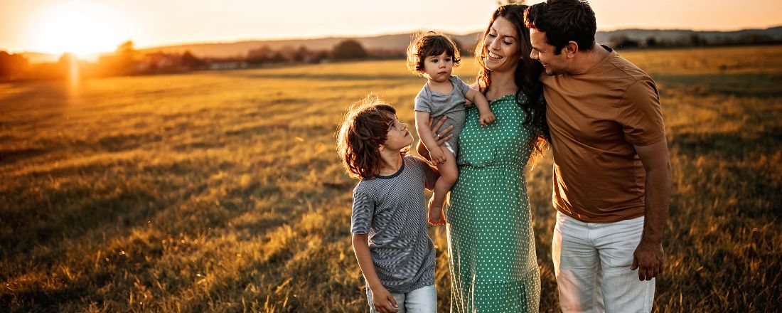 A happy young family walking at sunset.